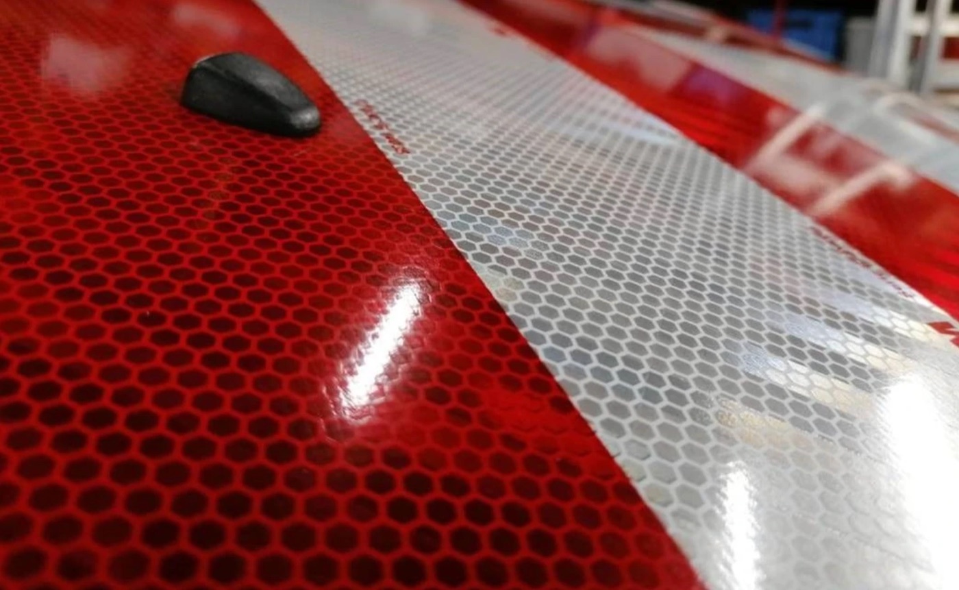 Rood-witte reflecterende folie op een werkvoertuig